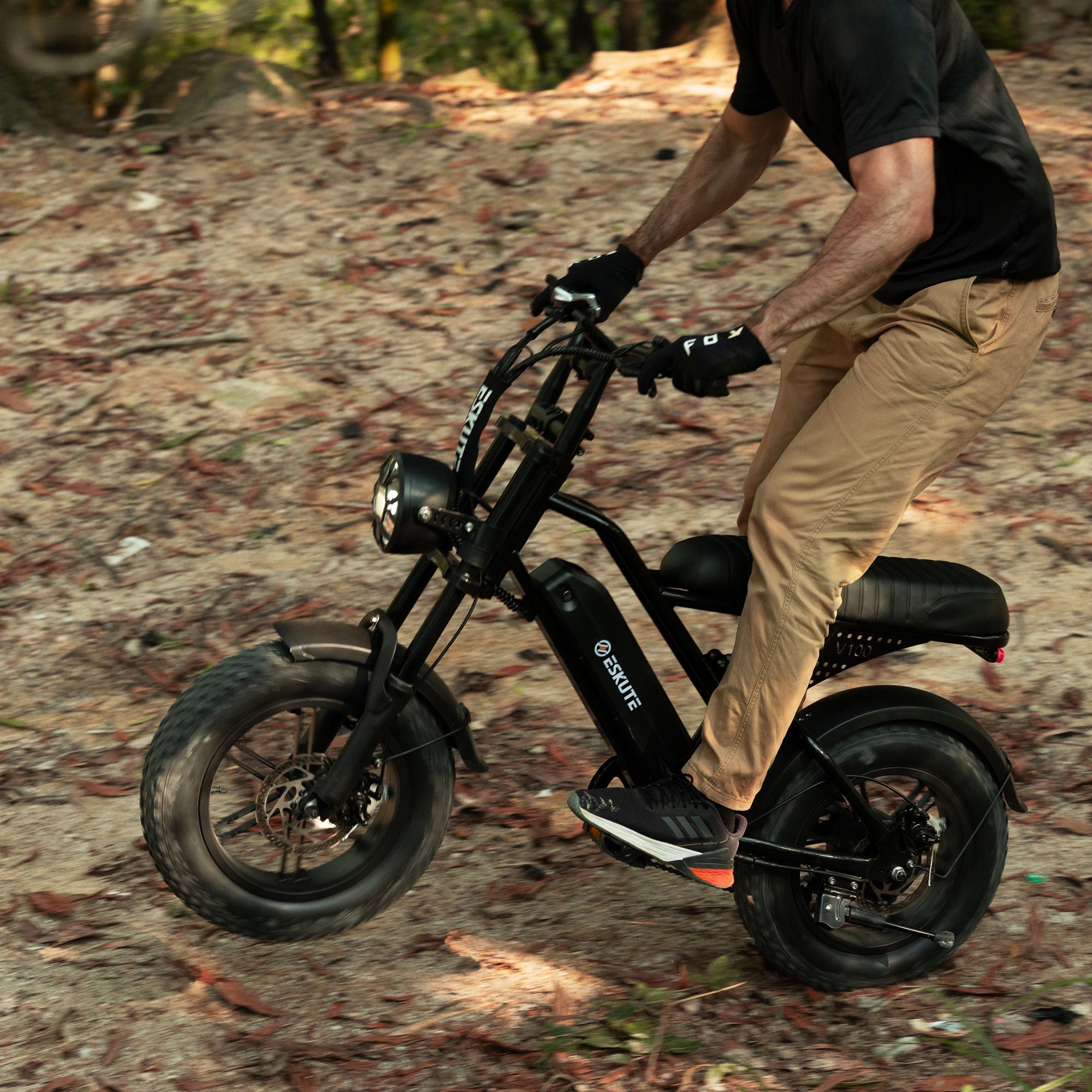 Person riding a black electric bike on a forest path